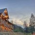 Hearthstone Elegant Lodge by the River in Kamiah, lodge exterior at dusk with mountain and tree views