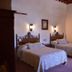 Hotel del Vasco in Zacatecas guest room with two twin beds and rustic wood headboards