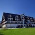 Hotel Paryski Art & Business in Zakopane, mountain-style hotel exterior with green lawn and clear blue sky