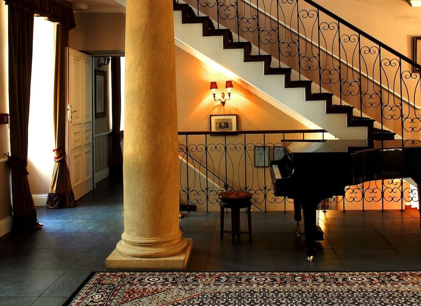 Dwór Sieraków in Sieraków, Małopolskie: grand staircase beside a piano and decorative column interior