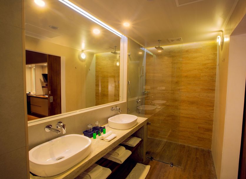 Sevana City Hotel Kandy bathroom with double vessel sinks, large mirror, and walk-in shower
