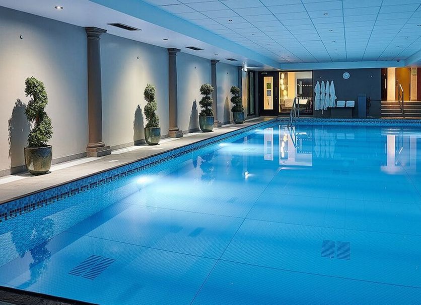 Grand Jersey Hotel and Spa indoor swimming pool in Saint Helier with blue-lit water and lounge area
