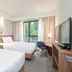 Hampton by Hilton Oswiecim guest room with two beds, desk, TV and window view in Oświęcim