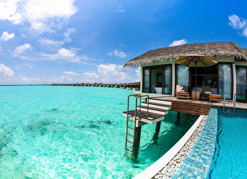 The Residence Maldives, Falhumaafushi: overwater villa with deck and steps into turquoise lagoon