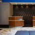 Courtyard by Marriott New York Manhattan/Fifth Avenue lobby with two wood reception desks and blue seating
