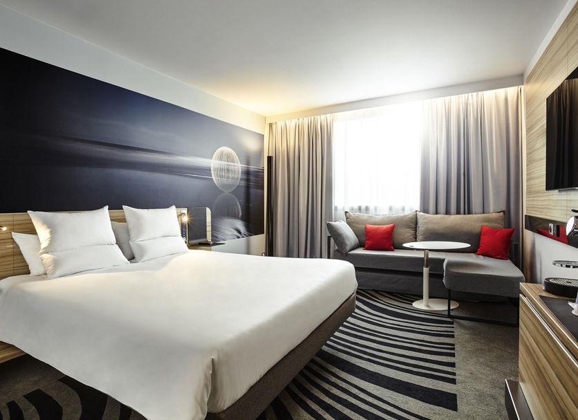 Novotel Marne la Vallée Noisy le Grand room with king bed, sofa, and window seating