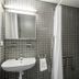 Residencia Universitaria Resa Roberto De Nobili bathroom with sink, mirror, shower and gray tiled walls in Sant Cugat del Vallès