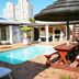 Dolphin Inn Blouberg in Cape Town with a small outdoor pool, patio seating, and thatched umbrella