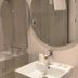 Hotel Mediterráneo by Croma in Estepona bathroom with shower, round mirror and sink