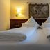 Hotel Weisses Haus in Bad Kissingen: twin beds with white linens and wall sconces in a guest room