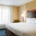 Fairfield Inn and Suites by Marriott Weirton guest room with king bed, desk, chair, and window with curtains