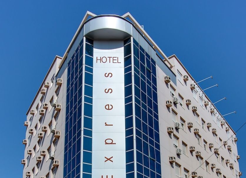Hotel Express Aeroporto in Porto Alegre, exterior view of a modern corner hotel under a clear blue sky