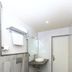 Hotel NavaRATNA Coimbatore bathroom with wall-mounted toilet, glass shower and sink