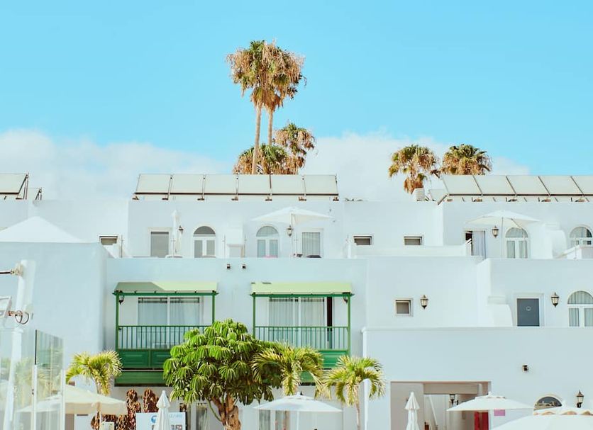 Gloria Izaro Club Hotel in Puerto del Carmen with white resort buildings and palm trees