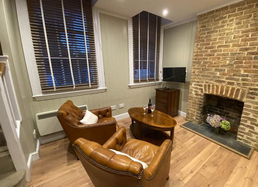 The Old Railway Station in Petworth lounge with leather chairs, brick fireplace and wood floors