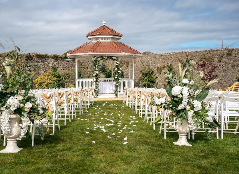 County Arms Birr outdoor wedding setup with white chairs, floral arrangements and gazebo
