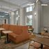 Hampton Inn & Suites Charlotte Ballantyne lobby seating area with high windows and dining tables