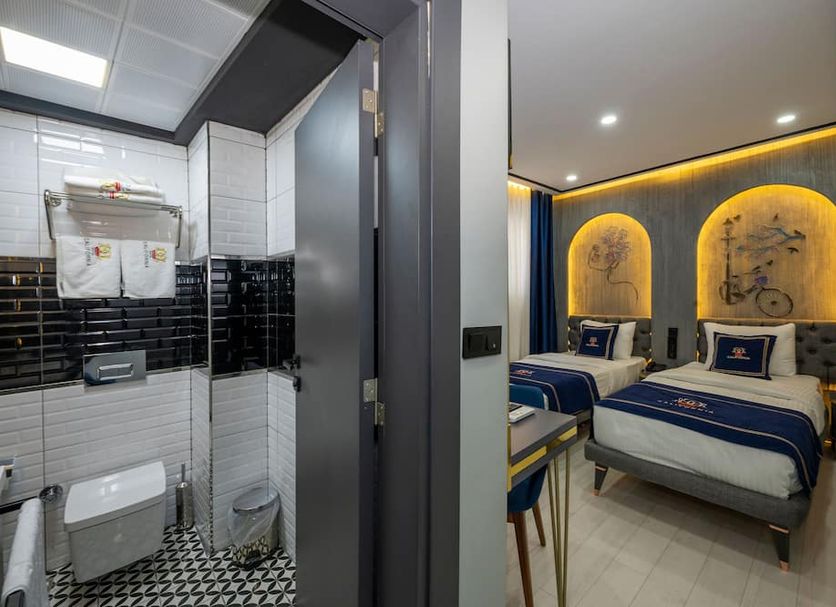 Hotel California in Istanbul: modern twin bedroom beside a glass-enclosed bathroom