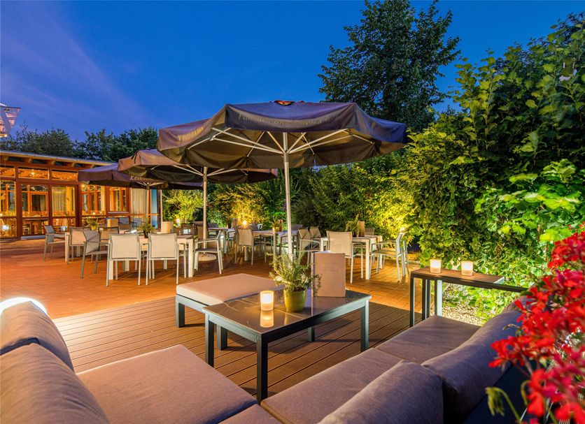 Best Western Plus Kurhotel an der Obermaintherme terrace with dining tables, umbrellas and lush greenery in Bad Staffelstein