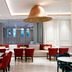 Radisson Hotel Chateau de Bangkok lounge in Bangkok with red chairs, white banquettes and a large pendant light