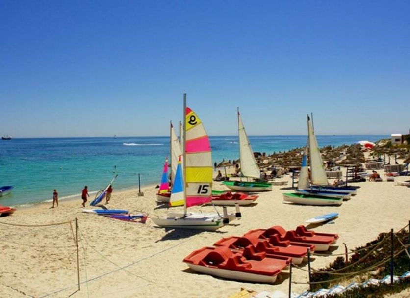 Seabel Alhambra Beach Golf & Spa in Port El-Kantaoui with sailboats on a sandy beach by turquoise sea