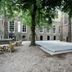 De Utrechtsche Dom in Gouda courtyard with tree, gravel seating area and historic brick buildings