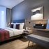 Citadines Arnulfpark Munich guest room with king bed, wall-mounted TV and floor-to-ceiling window in Munich