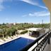 Hotel Aphrodite in Stoupa with balcony view of pool, sun loungers and surrounding hillside