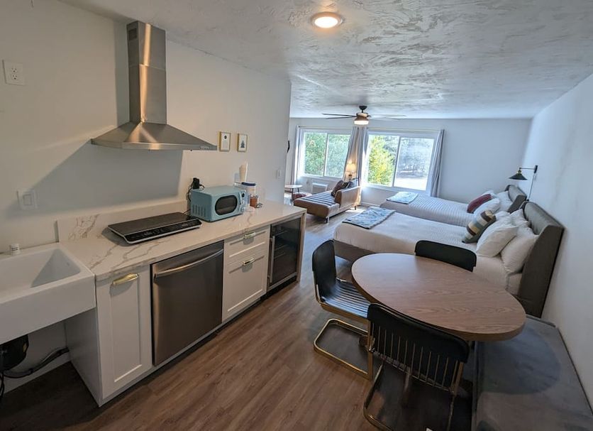 Sierra Blue Hotel & Swim Club kitchen and living area with sofa, table, and window view in Big Bear Lake