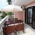 Apartments Alissa in Hvar balcony with table, chairs, and umbrella beside open shutters