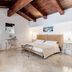 La Terra in Ostuni guest room with wood-beam ceiling, twin beds, and small vanity
