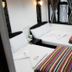 Woodstock Hostel Hong Kong twin room with two single beds, striped blankets and window curtains