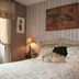 Le Petit Nailly in Magny-les-Hameaux bedroom with floral bed, bedside lamps and painted wall art
