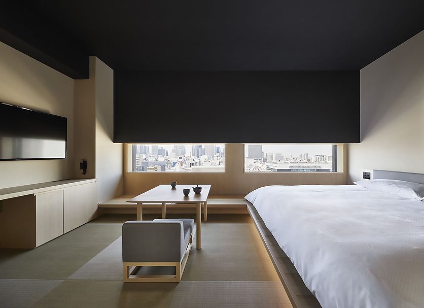 Onsen Ryokan Yuen Shinjuku Tokyo room with city view, low table, bench and bed