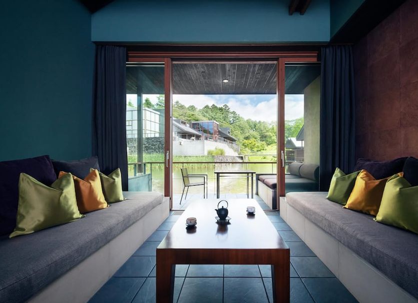 Hoshinoya Karuizawa lounge with floor-to-ceiling windows overlooking lush Karuizawa greenery