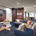 Courtyard by Marriott Johnson City lounge with sofas, armchairs, wall-mounted TV and glass coffee table