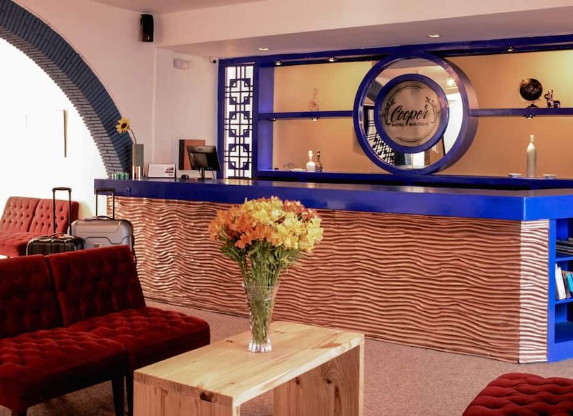 Cooper Hotel Boutique in Cusco lobby bar with blue counter, red velvet seating and flower vase