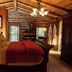 Chalet of Canandaigua bedroom with log cabin walls, wooden ceiling, and king bed in Canandaigua