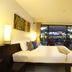 Palmyra Patong Resort Phuket room with king bed and balcony view of the pool in Patong