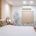 The Goose House Ubon room with bed, wardrobe, wall-mounted TV, and tropical wall mural in Ubon Ratchathani