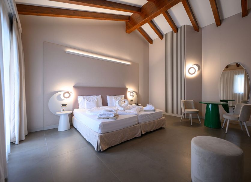 Villa Nicolli Romantic Spa Resort - Adults Only room in Riva del Garda with twin bed, wooden beams and seating area