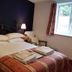 Glenan Lodge Self Catering in Inverness bedroom with double bed, bedside lamps and window
