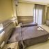 Sofia Hotel Heraklion guest room with three single beds, desk, wall TV and balcony door