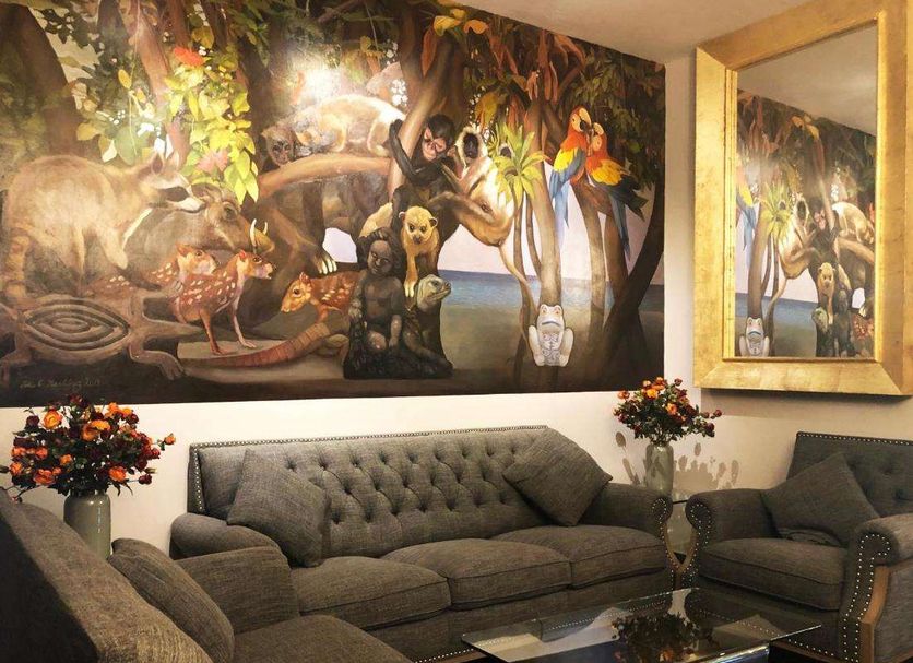 Villablanca Garden Beach Hotel in Cozumel lobby with jungle mural, gray sofas and glass coffee table