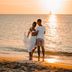 Amsterdam Manor Beach Resort in Noord: couple standing on the beach at sunset by the ocean