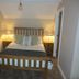 The Kings Head in Meifod bedroom with wooden bed, bedside lamps, and neutral decor