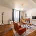Les Suites de Bellac living room in Bellac with armchair, coffee table, TV, and window light
