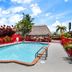 Super 8 by Wyndham Florida City/Gateway to Keys/Everglades pool with red fencing and tropical landscaping