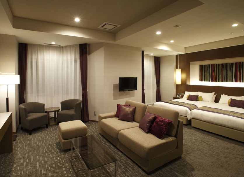 Noboribetsu Grand Hotel in Noboribetsu guest room with two beds, sofa seating, and wall-mounted TV