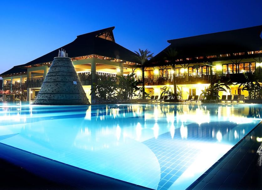 Aqua Fantasy Aquapark Hotel & Spa in Selçuk with illuminated resort pool at dusk